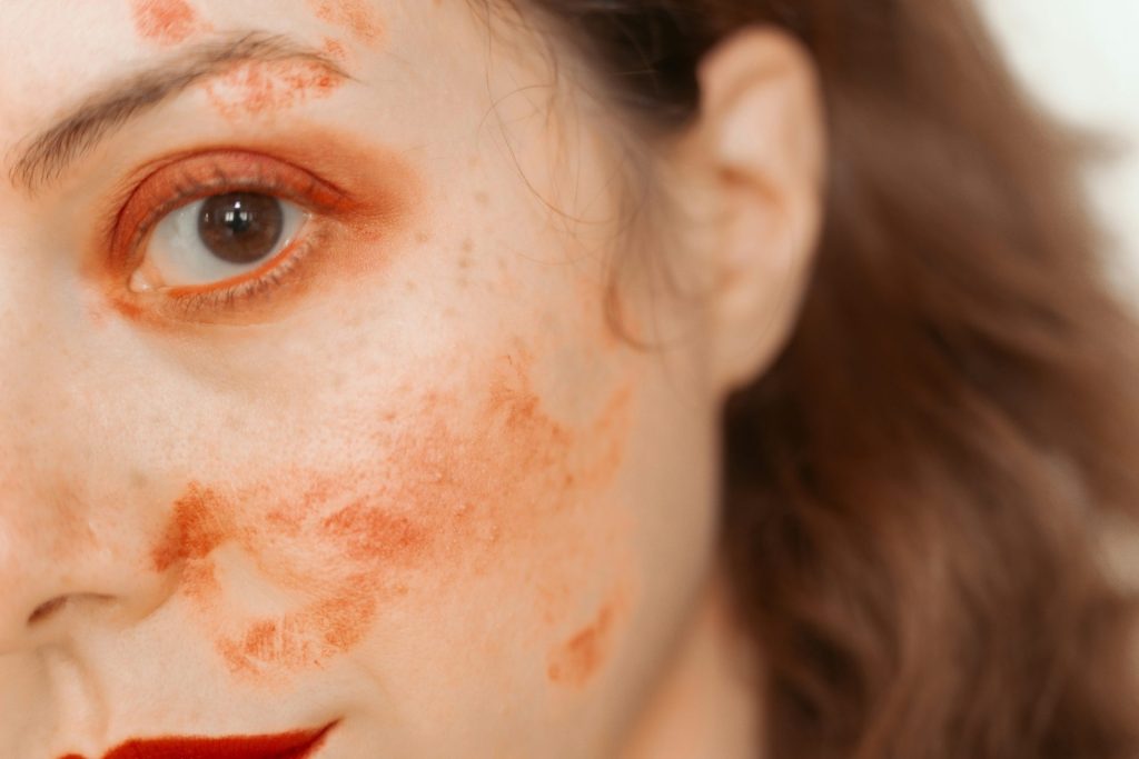 Woman with red paint smudges on face